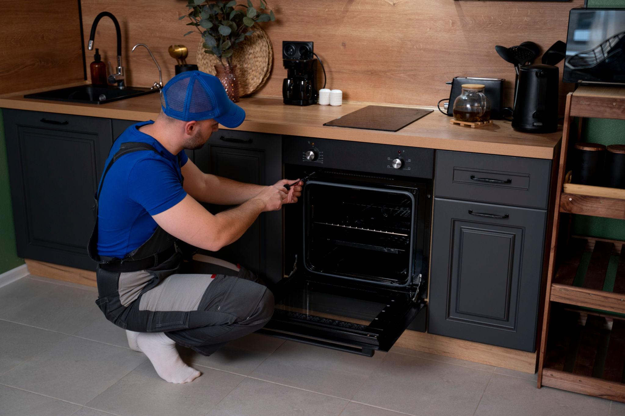 Technician repairing built-in oven during professional oven repair service at home